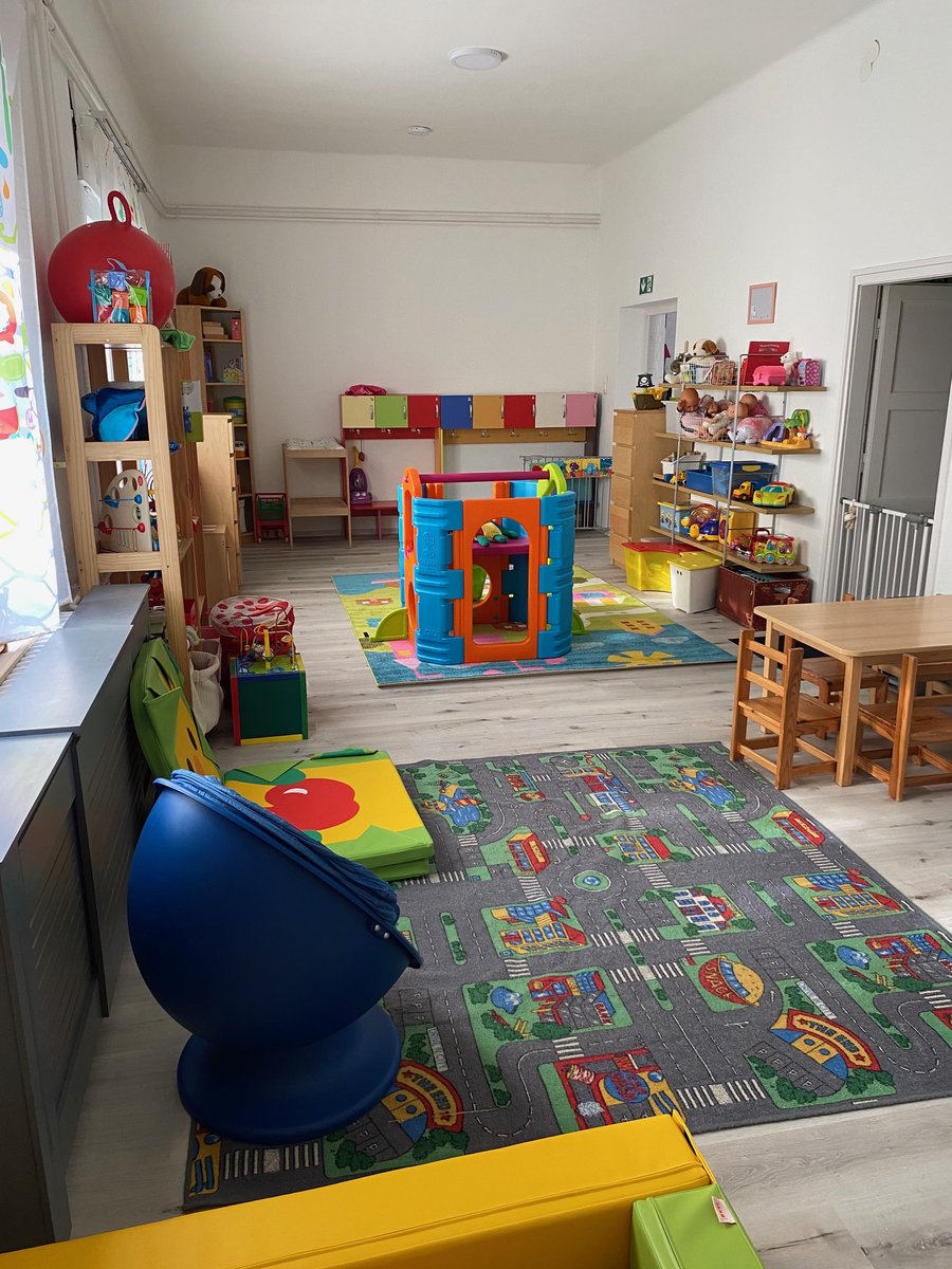 Otthonos csoportszoba színes játékokkal, könyvekkel és puha kuckóval